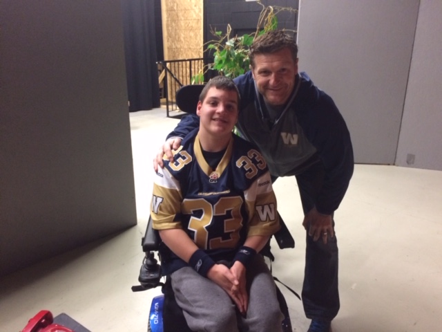 Jordan, in his wheelchair, meets Mike O'Shea, bending down
