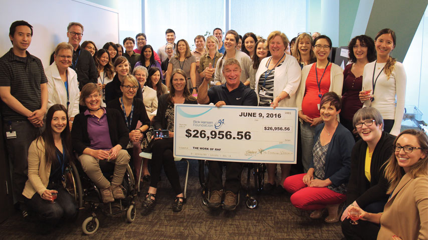 Rick and staff at the Rick Hansen Foundation with a cheque of $26,956.56