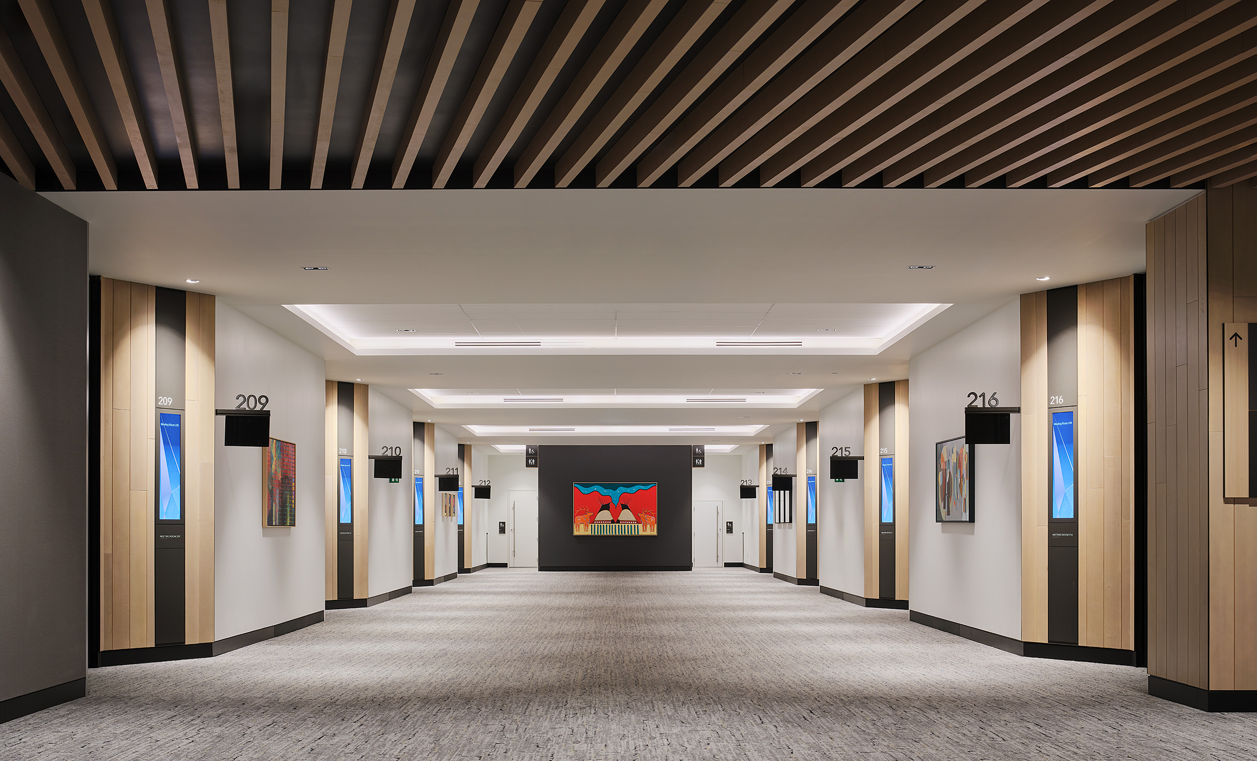 The long and wide hallways of the BMO Convention Centre where rooms are divided. The interiors are black, white, and neutral colours.