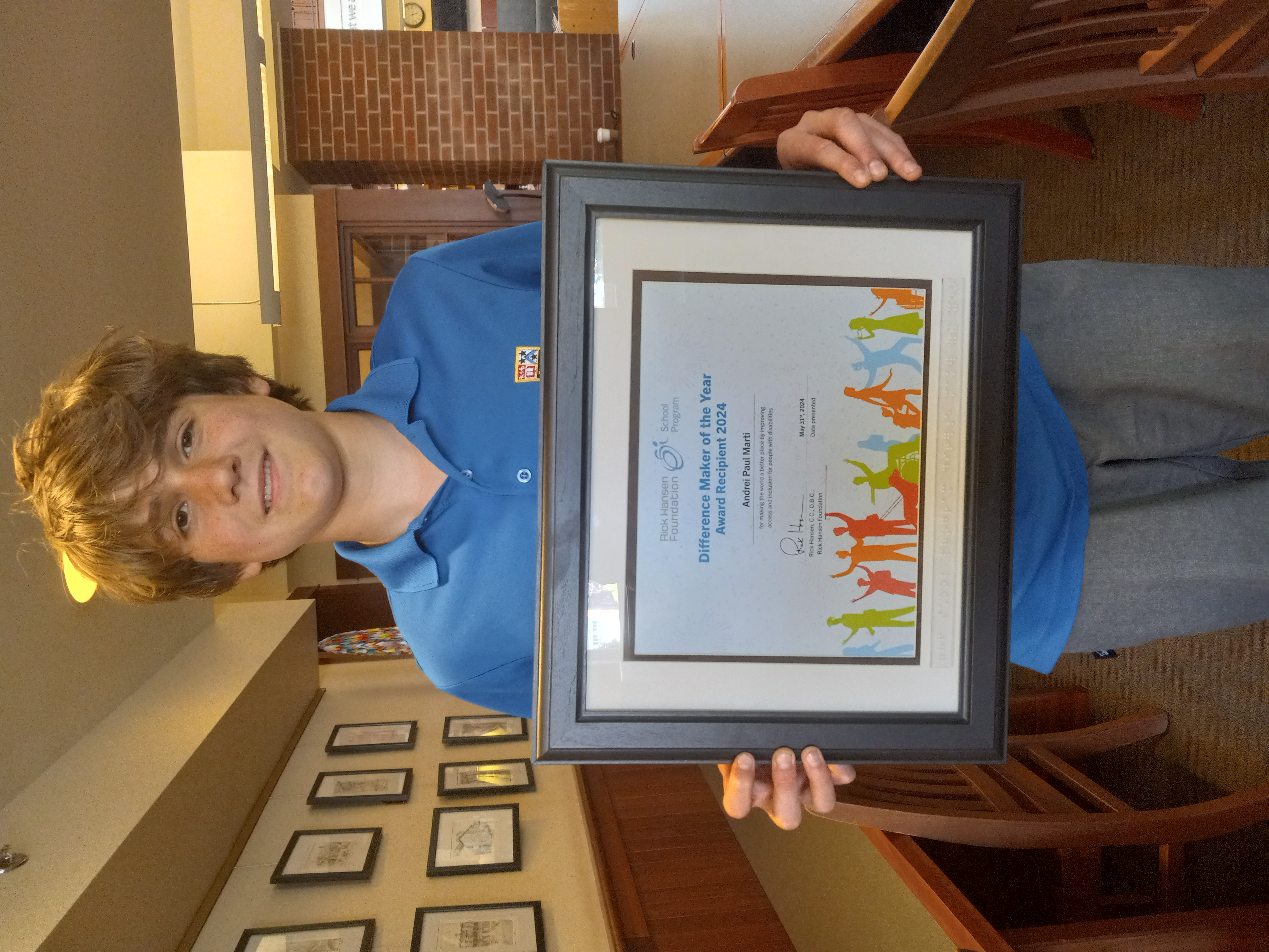 Andrei holds his framed Difference Maker of the Year Award