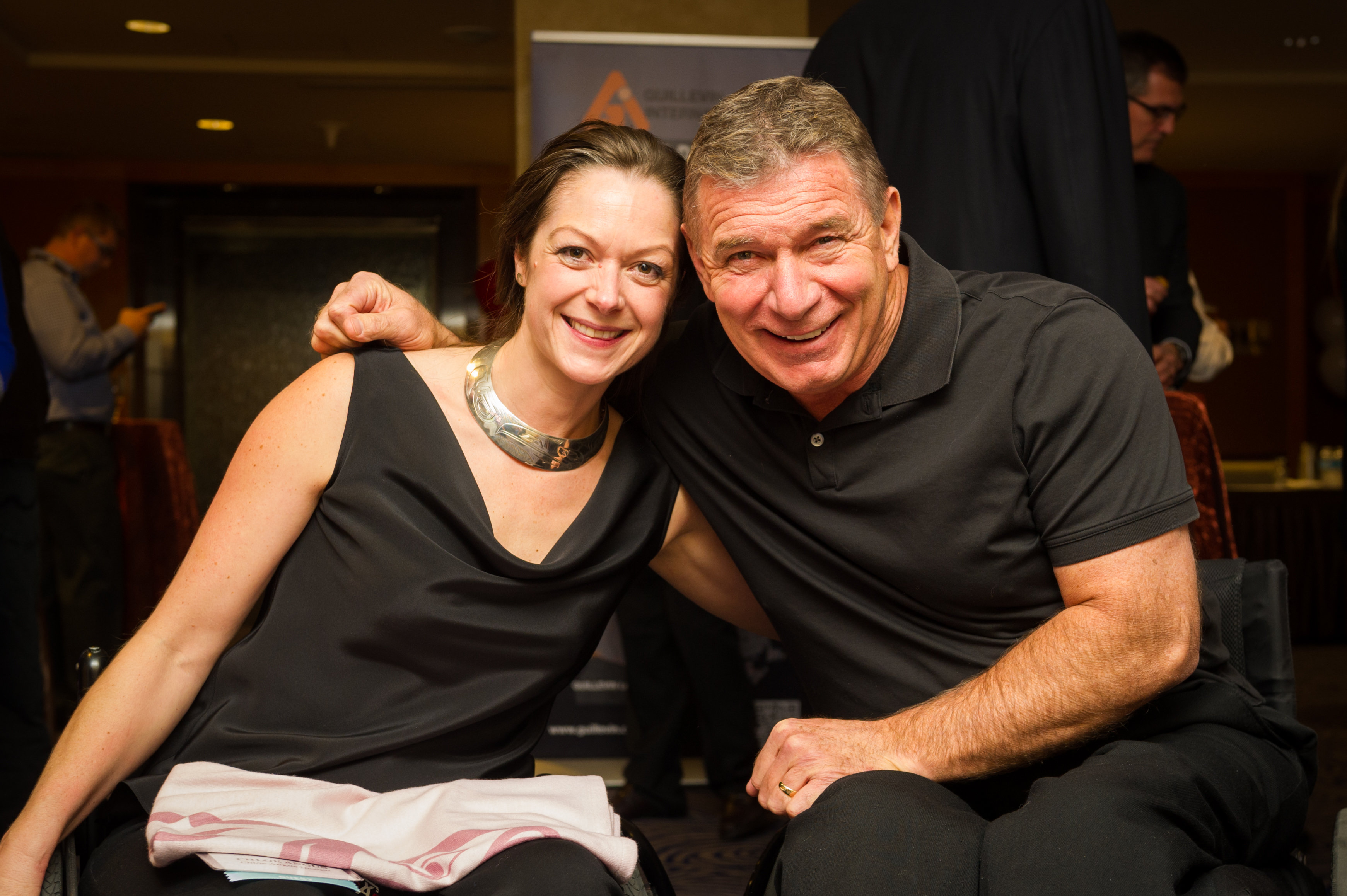 Chloe with Rick Hansen at an event, both smiling widely at the camera.