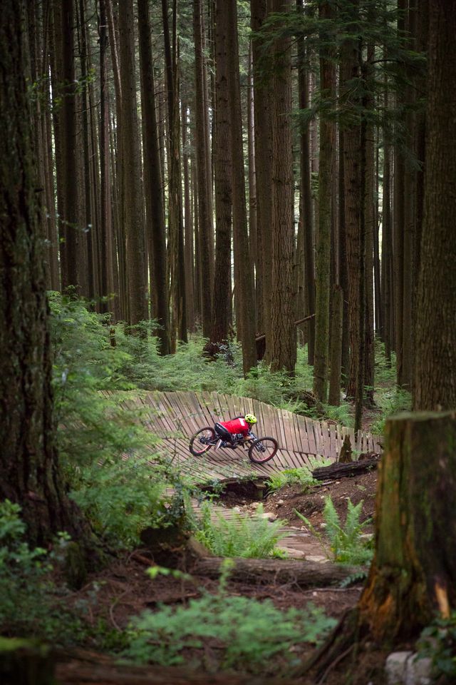 Tara rides her bike over a curved wooden ramp