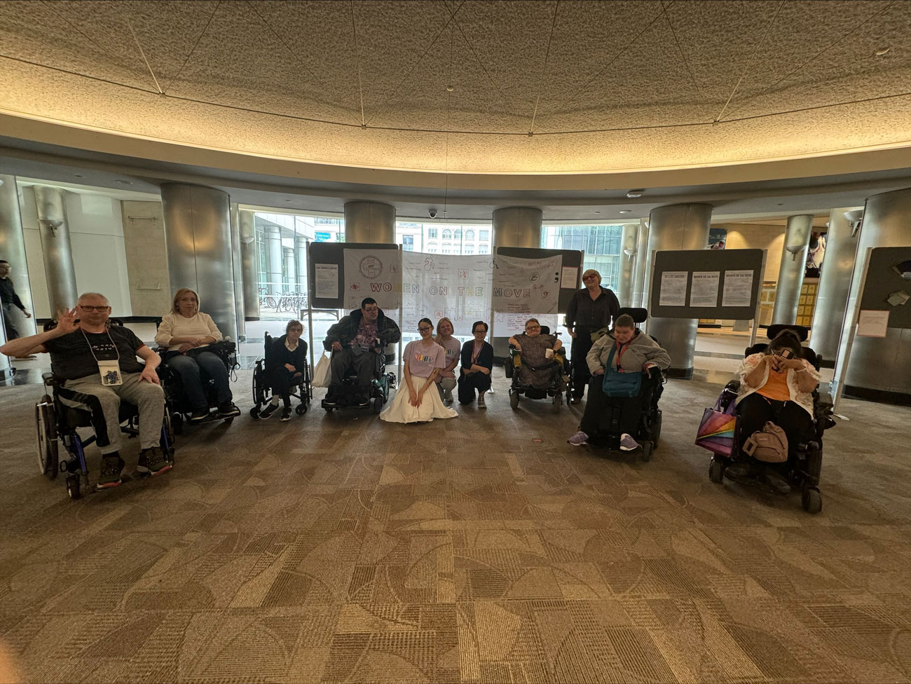 group of women, some using wheelchairs in a round, carpeted room