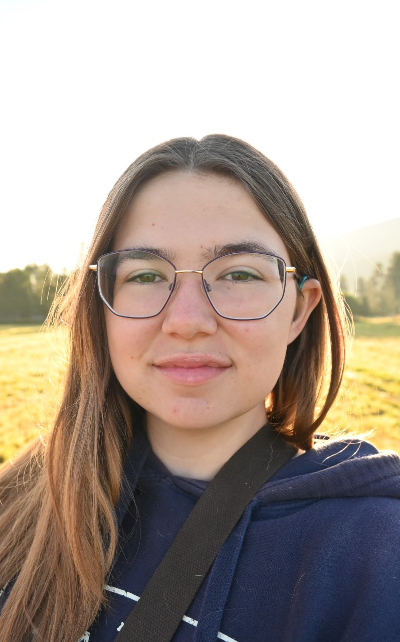 Girl with blonde hair and glasses outside