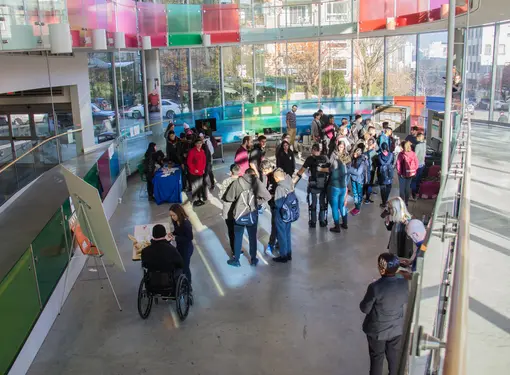Students and people with physical disabilities gather in the atrium of the Blusson Spinal Cord Centre