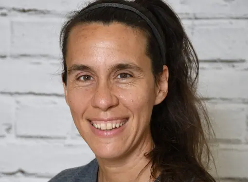 Veronique Messier, who has large dark hair in a ponytail and is wearing a grey t-shirt.