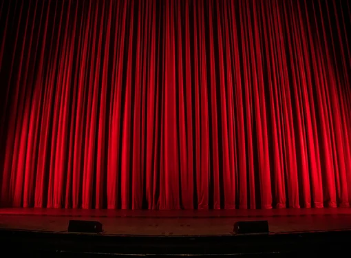 An image of theatre red curtains