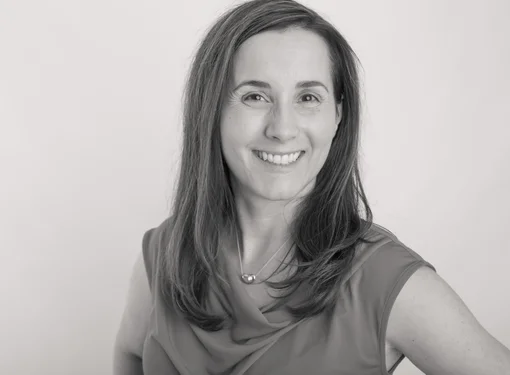 Woman with shoulder length hair, professional attire, smiling 