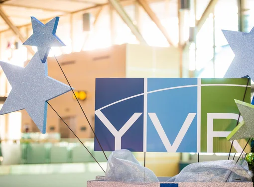 Image of YVR logo in blue and green with celebratory starts surrounding it