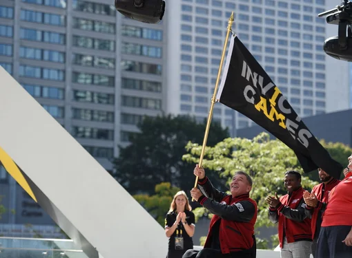 Rick was an Ambassador for the 2017 Invictus Games.  The photo pictures Rick, on the eve of the opening ceremonies, waiving the Invictus Games flag. Photo courtesy of Invictus Games 2017.