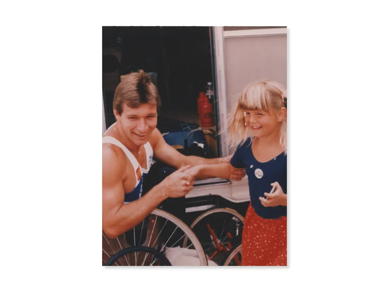 Rick Hansen during the Man In Motion World Tour, shaking hands with a young girl with blonde hair.